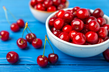 Cherries. Fresh ripe cherries with leaves on a textured wooden background. Fresh sweet organic cherry pile. Berries and fruits. Vegan. Healthy eating. Place for text. Copy space
