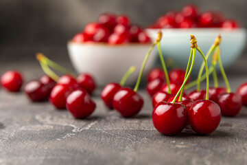 Cherries. Fresh ripe cherries with leaves on a textured wooden background. Fresh sweet organic cherry pile. Berries and fruits. Vegan. Healthy eating. Place for text. Copy space