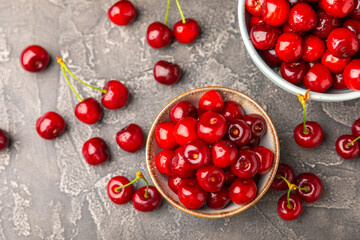 Cherries. Fresh ripe cherries with leaves on a textured wooden background. Fresh sweet organic cherry pile. Berries and fruits. Vegan. Healthy eating. Place for text. Copy space
