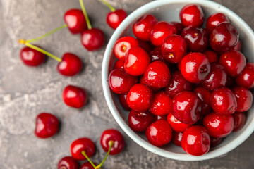 Cherries. Fresh ripe cherries with leaves on a textured wooden background. Fresh sweet organic cherry pile. Berries and fruits. Vegan. Healthy eating. Place for text. Copy space