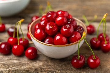 Cherries. Fresh ripe cherries with leaves on a textured wooden background. Fresh sweet organic cherry pile. Berries and fruits. Vegan. Healthy eating. Place for text. Copy space