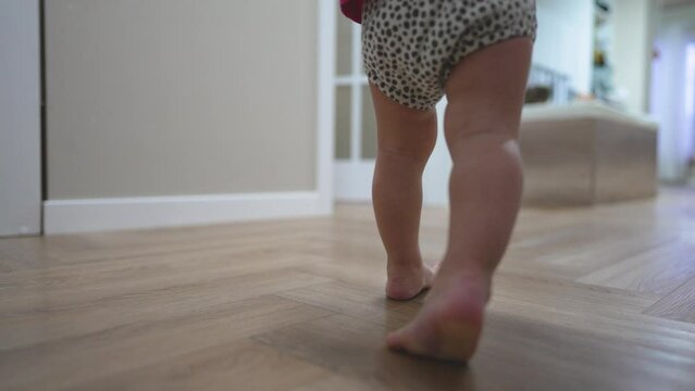 Barefoot toddler learn to walk at home taking first step with determination. family look first step and is filled with joy and pride. First step symbolize growth unforgettable moment cherished forever