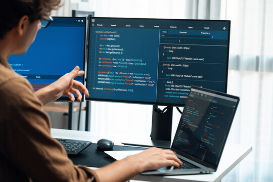 IT developer working online software development on pc monitors at modern home office on coding application screens, creating updated latest program firmware information version concept. Gusher.