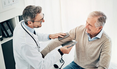 Blood pressure, man and doctor in office with support, help and advice for health insurance. Clinic, senior patient and medical professional at desk with consultation, trust and healthcare at checkup