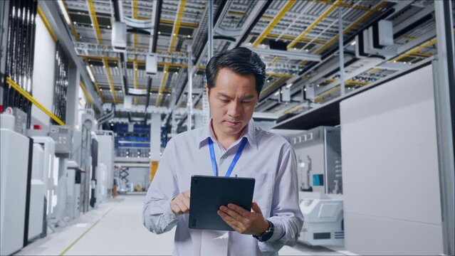 Asian Male Professional Worker Standing With His Tablet At Factory Digitalization, Work Continuously With His Tablet