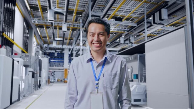 Shot Captures Of An Asian Male Professional Worker Standing At Factory Digitalization, His Broad Smile At The Camera