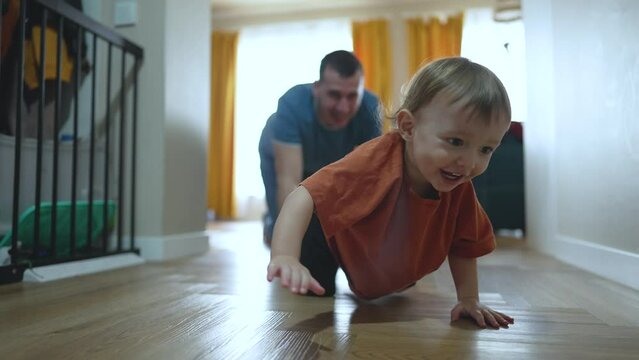 Family together dad teaches baby first steps. Supportive dad with baby walking lessons at home. Dad and baby together family bonding through step by step learning. Family unity in teaching baby walk.