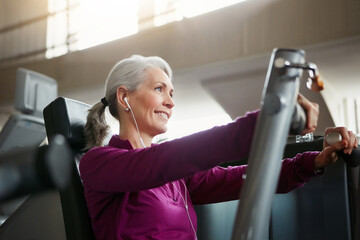 Mature, happy woman and chest press with machine for workout, fitness or indoor exercise at gym....
