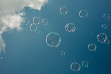 soap bubbles against the background of the sky with clouds, view from below