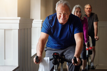 Training, cycling and senior man in gym for spinning class, exercise and fitness with physical...