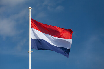 Dutch flag waving atop of its pole