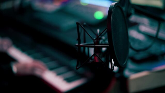 the recording room is dark with neon lighting in a soundproof room for recording songs or voice-overs an expensive microphone with filter