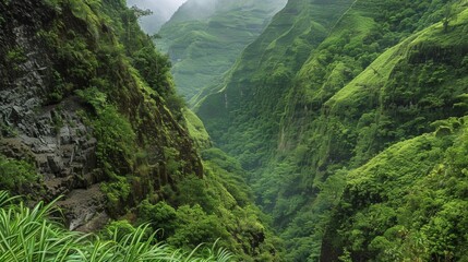 A lush green valley marked by unstable cliffs and steep slopes prone to frequent landslides.