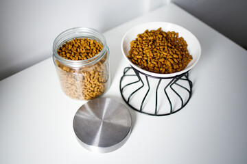 Dry cat food in the bowl and in the glass jar
