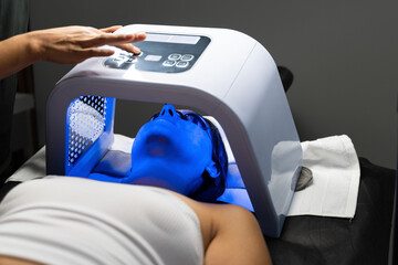 Woman undergoing a led light mask facial treatment for skin health and beauty enhancement