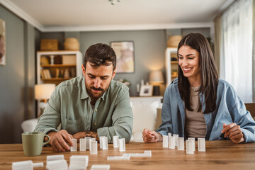 boyfriend and girlfriend play dominoes at home have fun together