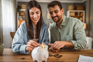 Happy boyfriend and girlfriend save money together in the piggy bank