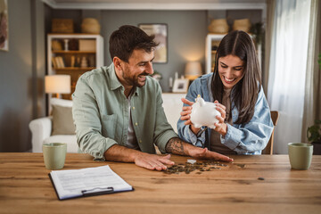 Happy boyfriend and girlfriend save money together in the piggy bank