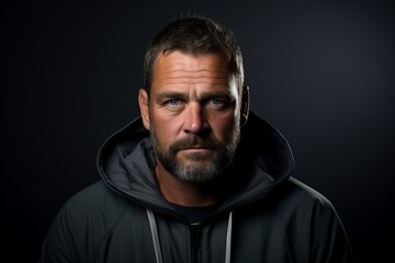 Obraz premium Portrait of a handsome man with a beard and mustache in a black hoodie.