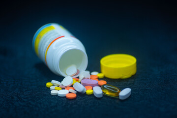 Close shot of different medical health supplement pills for all illnesses with an open can