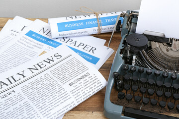 Newspapers with vintage typewriter on wooden table