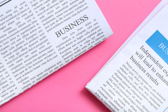 Different newspapers on pink background