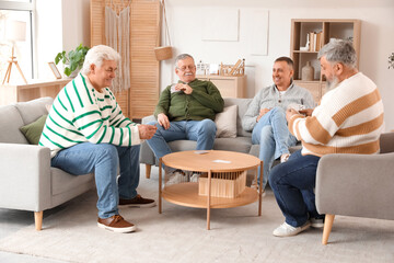 Elderly men playing cards at home