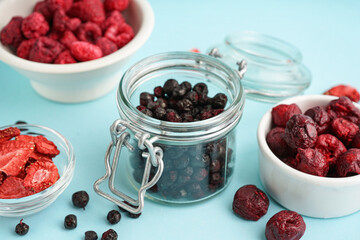Jar with freeze-dried blueberries on blue background