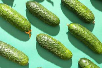 Fresh green cucumbers on color background