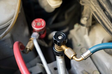 Close up a refrigeration charging hoses connect with a tube to an air car compressor.