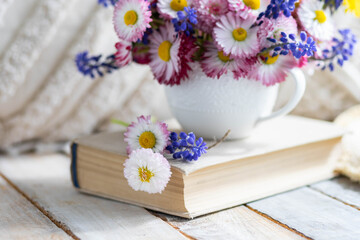 Bouquet of daisy with pink flowers in a ceramic white mug, wooden background. Romantic still life, summer or spring inspiration, cozy home decor. Greeting card for birthday, anniversary, Mother's Day