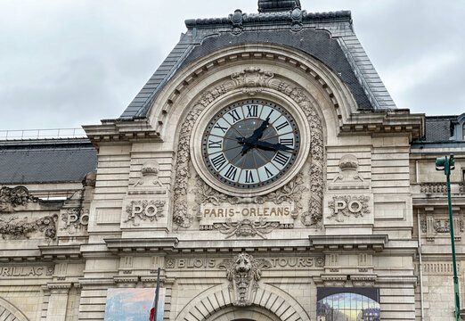 A large clock on a building with the words Paris Orleans written on it