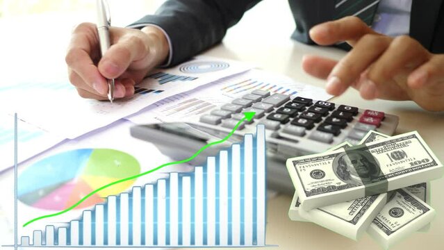 Empresario haciendo c&aacute;lculos contables, usando calculadora y tomando nota de los intereses y las ganancias, gr&aacute;fico de barras con tendenica creciente, dinero, d&oacute;lares girando