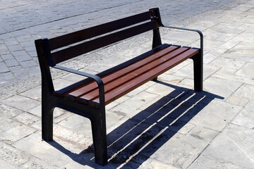 A bench for relaxing in a city park on the seashore.
