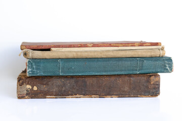 Old damaged books stacked on top of each other. Yellowed natural paper texture. On isolated white background. Clean close-up.