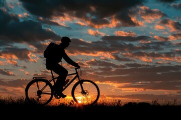 Obraz premium A person rides a bike against the backdrop of a beautiful sunset, with warm colors and long shadows
