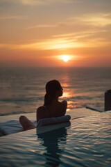 A person relaxing by the water's edge as the day ends