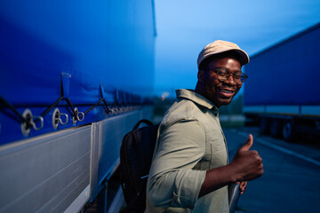 Happy truck driver holding thumbs up celebrating money income.