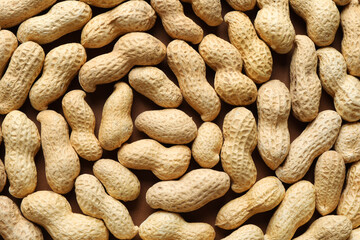 Many fresh unpeeled peanuts as background, top view
