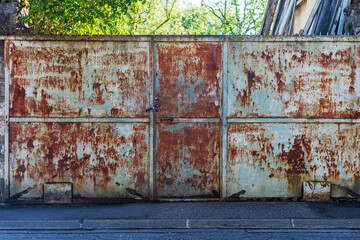 Rusted Metal Gate with Padlock on Urban Street