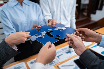 Corporate officer worker collaborate in office, connecting puzzle pieces with report paper on table...