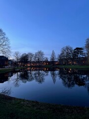 Obraz premium Scenic view of river and buildings on shore in evening