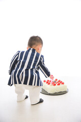 ケーキのイチゴを食べようとする小さな男の子