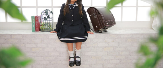 茶色のランドセルの隣に座る女の子