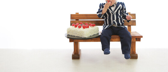 お誕生日のケーキの苺を食べようとする1歳の男の子