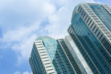 Obraz premium Modern office buildings exterior towering against blue sky. Jakarta Indonesia skyline viewed from below with facade of apartments, condominiums and offices.
