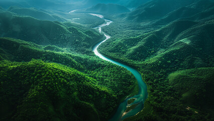 Aerial view of a winding river through lush green mountain landscape