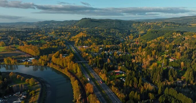 Green mountainous landscapes of Oregon countryside at sunset. Footage above two parallel highways with some transport on. Top view.