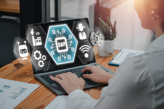 SAP, System Applications and Products in Data Processing concept, Businesswoman using laptop computer on desk with System Applications and Products in Data Processing icon on virtual screen.