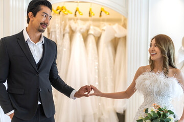 Portrait of smiling cheerful happy love asian couple fashion bride man and woman posing in white wedding dress for pre wedding hug together at wedding interior fashion studio
